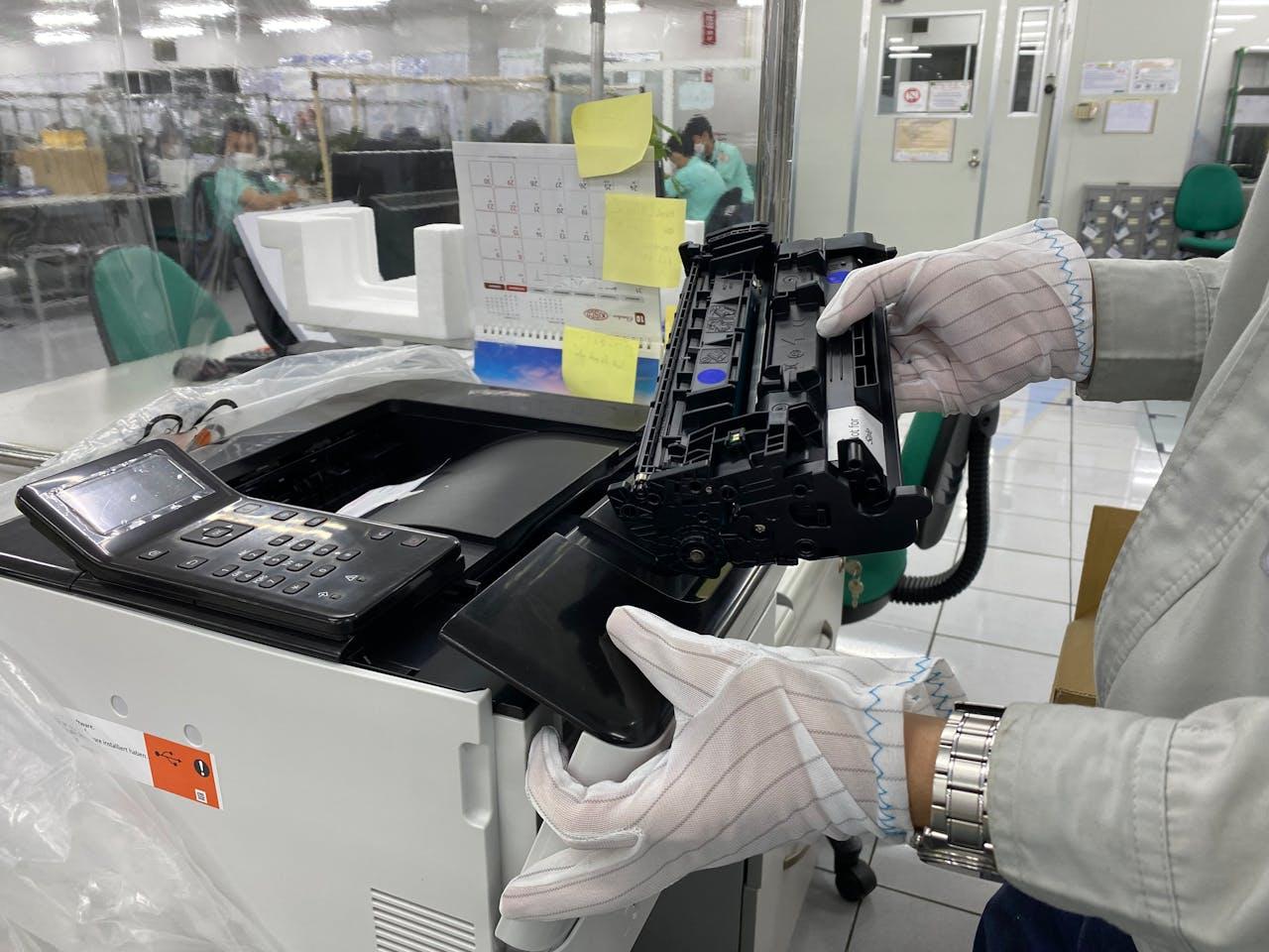 tecnico con in mano un fusore che lo sostituisce in una stampante